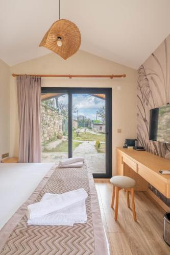 a bedroom with a bed with a desk and a window at Baska Urla Otel in Denizli