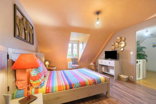 a bedroom with a bed and a tv in it at Le Lys De Mer - Chambre in Dragey