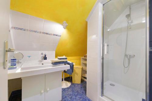 a bathroom with a white sink and a shower at Le Lys De Mer - Chambre in Dragey