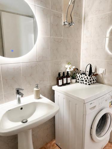 a bathroom with a sink and a washing machine at KallitheaDeluxe in Kallithea Halkidikis