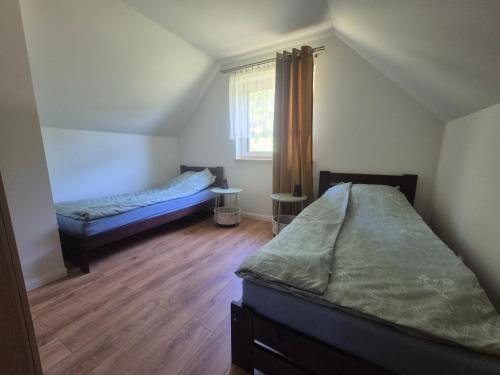 a bedroom with two beds and a window at Domek Ranczo Podkówka "przed" Bieszczady in Lipa