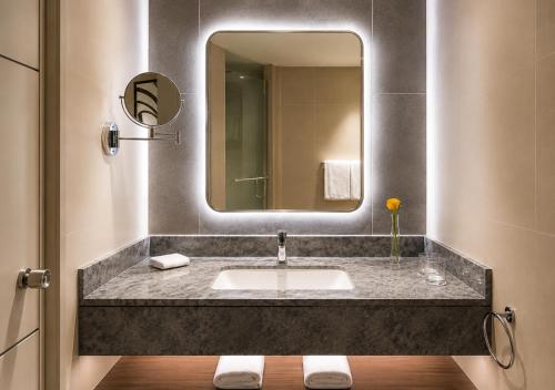 ein Badezimmer mit Waschbecken und Spiegel in der Unterkunft Crowne Plaza Riyadh Palace by IHG in Riad