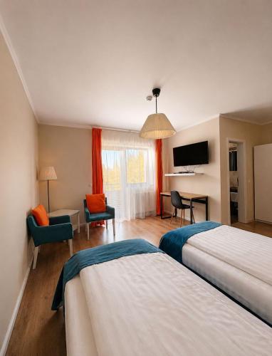 a hotel room with two beds and a desk at Transylvania Villa & Spa in Muntele Băişorii