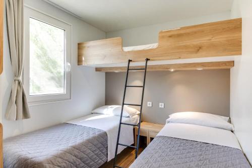 two bunk beds in a room with a window at Camping Adria Riccione in Riccione
