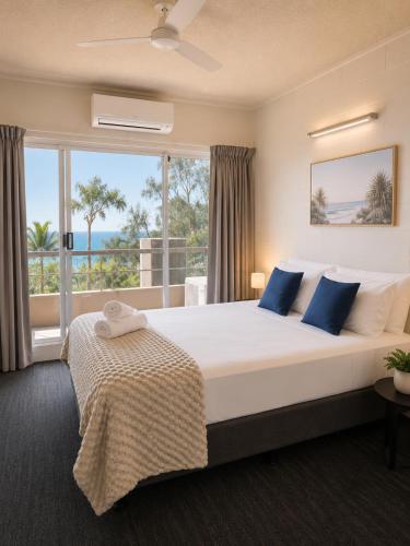 a bedroom with a large bed and a large window at Lumina Motel Gladstone in Gladstone
