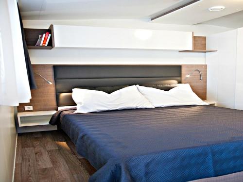 a bedroom with a bed with a black headboard at Auto kamp Cuka in Pakoštane