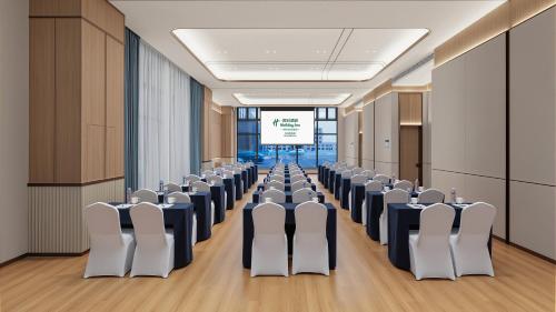 a conference room with rows of chairs and a screen at Holiday Inn Bayanbulak by IHG in Bayanbulak