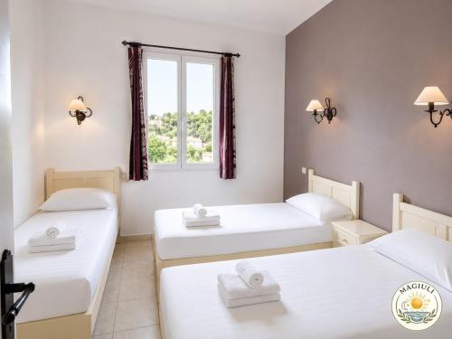 a room with two beds and a window at Magiuli Village du Rouret in Grospierres