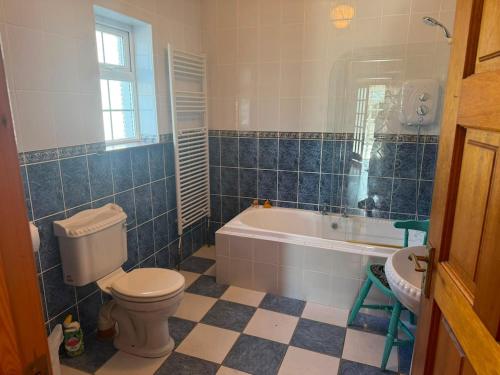 a bathroom with a toilet and a tub and a sink at Denmar Spacious coastal bungaow in Cleedagh Bridge