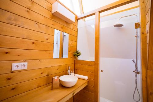 a bathroom with wooden walls and a sink and a shower at Kampaoh Cova Negra in Gandía