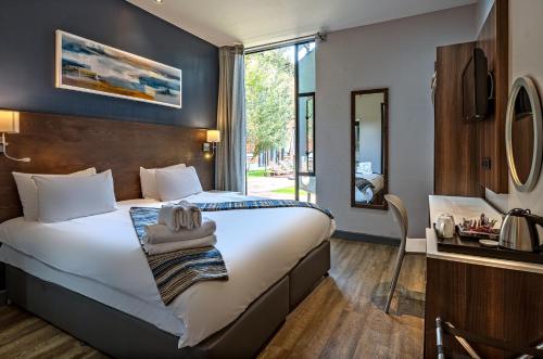 a hotel room with a large bed and a mirror at Aggeneys Hotel in Aggeneys