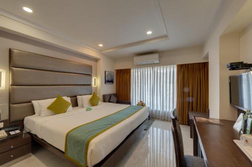 a hotel room with a bed and a flat screen tv at Hotel Suba Galaxy Mumbai in Mumbai