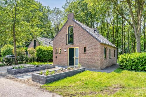 a brick house with a garden in the yard at 6 - Person Forest 183 Bungalow in Ewijk