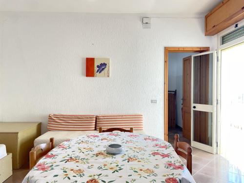 a bedroom with a table with a flower blanket on it at CASA CALIPSO - Casa a pochi passi dal mare delle Maldive del Salento in Salve