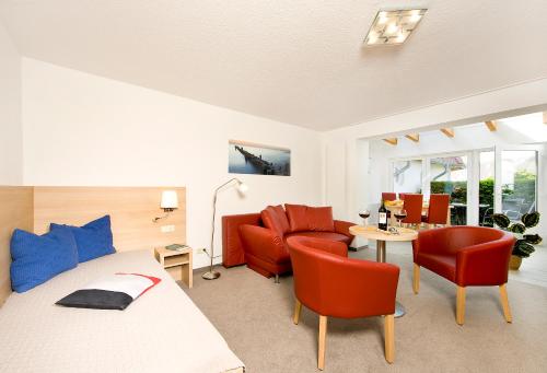 a bedroom with a bed and chairs and a table at Ferienhotel Bernstein in Trassenheide