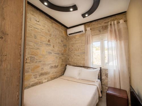 a bedroom with a bed and a brick wall at Cretan Nature Villa Alexandra in Zaros