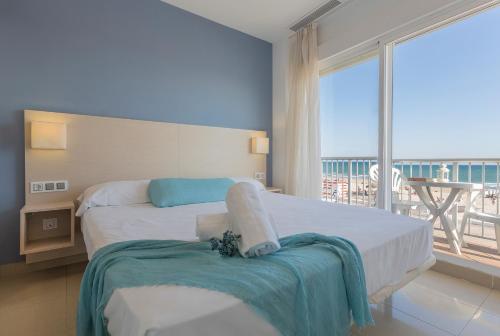 a bedroom with two beds and a large window at Apartamentos Playa Barbate in Barbate