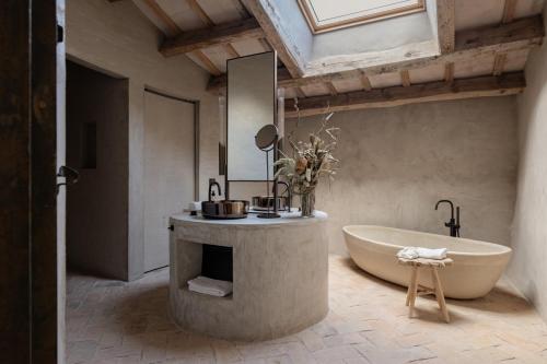 a bathroom with a tub and a large mirror at Hotel Vestige Binidufà in Isla de Menorca