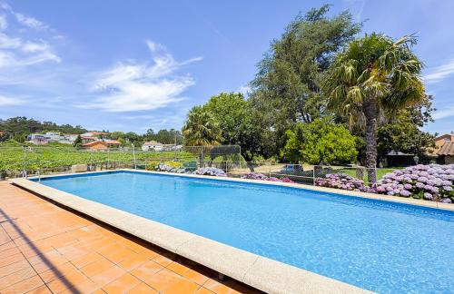 a large swimming pool in a yard with flowers at A casa dos Viñedos, finca con piscina privada in Bayón