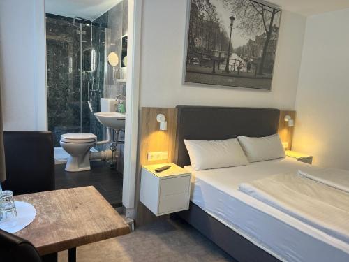 a small bedroom with a bed and a bathroom at Eifelerhof hotel Monschau in Monschau