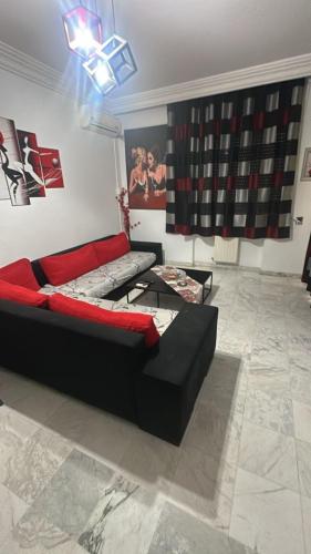 a living room with a black couch and a table at self checkin in Tunis