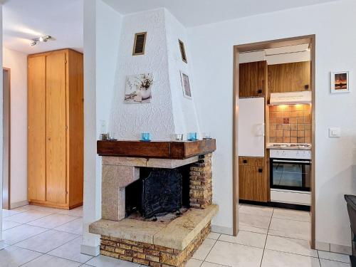a living room with a fireplace and a kitchen at Apartment Luchre by Interhome in Zermatt