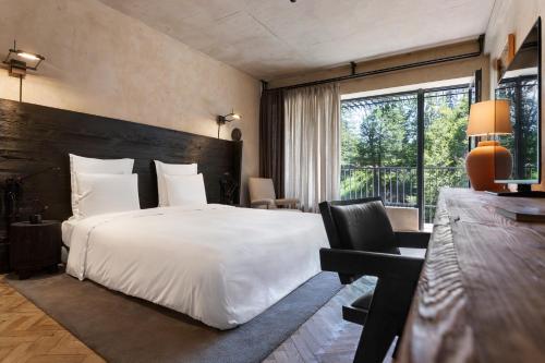a hotel room with a large bed and a desk at Kokhta Bakuriani in Bakuriani