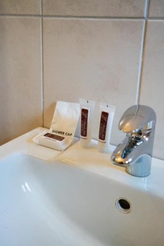 a bathroom sink with a book and a faucet at Guest Paradise Lodge in Victoria Falls
