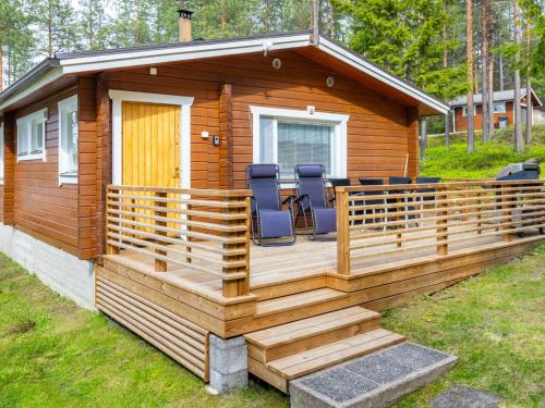 a cabin with a deck with chairs on it at Holiday Home Järvelä by Interhome in Kemijärvi