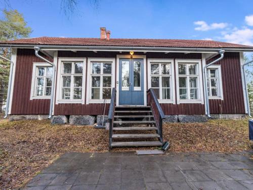 a small red house with a blue door and windows at Holiday Home Säikkäranta by Interhome in Oulunsalo