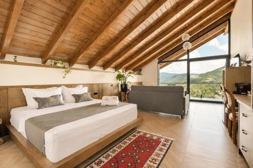 a bedroom with a large bed and a large window at Vila Harmoni Roshnik in Roshnik