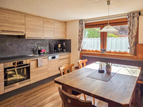 a kitchen with a wooden table and a dining room at Holiday Home Egger by Interhome in Aschau