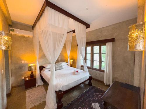 a bedroom with a canopy bed with white curtains at Beverly Suites - Two Bedroom Apartment 2-5min to Beach in Malindi