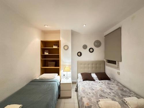 a small bedroom with two beds and a tv at Consell Habitaciones in Barcelona