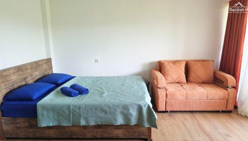 a bedroom with a blue bed and a chair at Bazaleti Hut in Bazalet'i