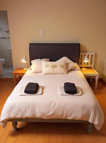 a bedroom with a large bed with two towels on it at Muizenberg Surfers Lodge in Muizenberg