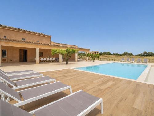 a swimming pool with lounge chairs next to a building at Holiday Home Can Toni by Interhome in Inca