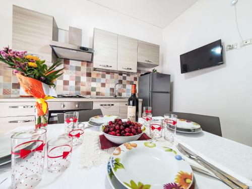 a kitchen with a table with a bowl of fruit and wine glasses at Holiday Home SinAgo by Interhome in Lascari
