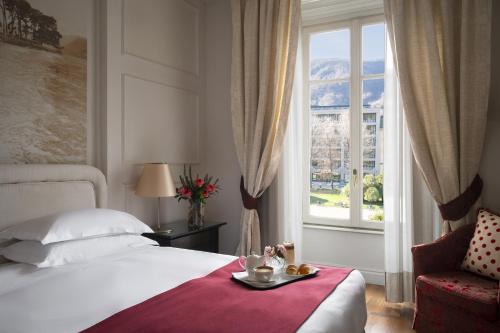 a bedroom with a bed and a window and a chair at Albergo Terminus in Como