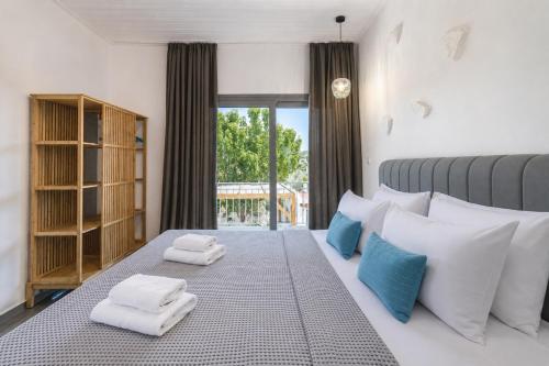 a bedroom with a large bed with towels on it at Agorastos Luxury Living in Platamonas