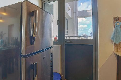 a refrigerator in a kitchen next to a window at Skyline Views Pool access Central Location in Yakbedda