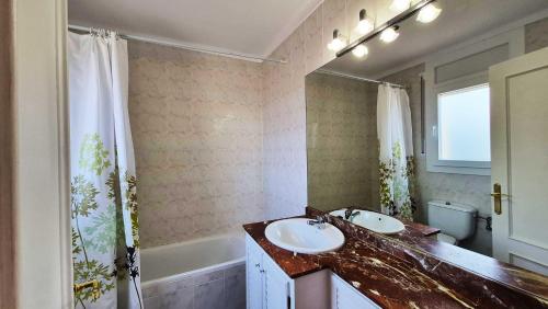 a bathroom with two sinks and a tub and a mirror at Villa Pals Carles Piscina in Pals