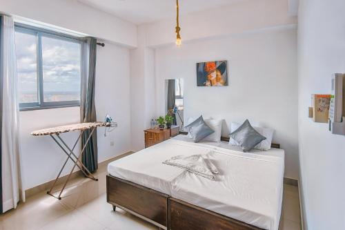 a bedroom with a bed with white sheets and a window at Skyline Views Pool access Central Location in Yakbedda