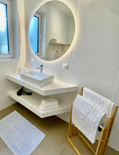 a white bathroom with a sink and a mirror at "Ellas Home Sekirn" - in 3min am Badestrand in Sekirn