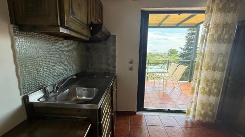 a kitchen with a sink and a view of a patio at Kastro in Skala Potamias