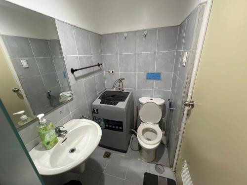 a small bathroom with a toilet and a sink at Sea Residences in Manila