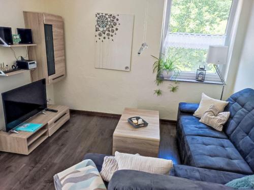 a living room with a blue couch and a tv at Apartment Ober Langengarten by Interhome in Pittenbach