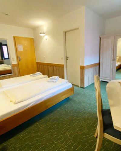 a bedroom with a bed and a chair in it at Burgblick Hohnstein - Pension in Hohnstein