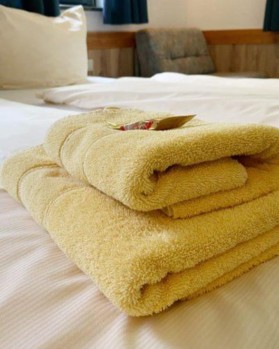 a towel is sitting on top of a bed at Burgblick Hohnstein - Pension in Hohnstein