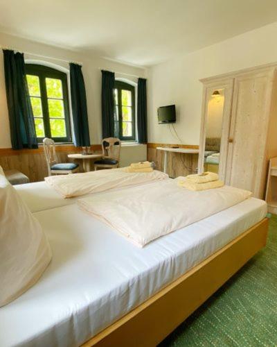 a bedroom with a large white bed with a mirror at Burgblick Hohnstein - Pension in Hohnstein